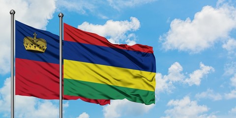 Liechtenstein and Mauritius flag waving in the wind against white cloudy blue sky together. Diplomacy concept, international relations.