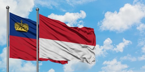 Liechtenstein and Monaco flag waving in the wind against white cloudy blue sky together. Diplomacy concept, international relations.