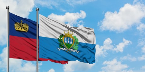 Liechtenstein and San Marino flag waving in the wind against white cloudy blue sky together. Diplomacy concept, international relations.