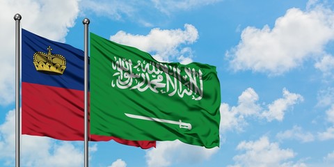 Liechtenstein and Saudi Arabia flag waving in the wind against white cloudy blue sky together. Diplomacy concept, international relations.