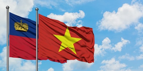 Liechtenstein and Vietnam flag waving in the wind against white cloudy blue sky together. Diplomacy concept, international relations.