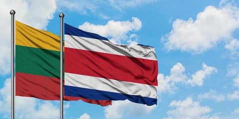 Lithuania and Costa Rica flag waving in the wind against white cloudy blue sky together. Diplomacy...