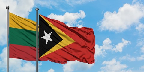Lithuania and East Timor flag waving in the wind against white cloudy blue sky together. Diplomacy concept, international relations.