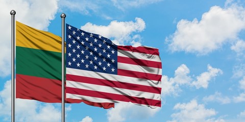 Lithuania and United States flag waving in the wind against white cloudy blue sky together. Diplomacy concept, international relations.