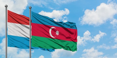 Luxembourg and Azerbaijan flag waving in the wind against white cloudy blue sky together. Diplomacy concept, international relations.