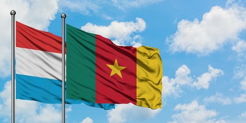 Luxembourg and Cameroon flag waving in the wind against white cloudy blue sky together. Diplomacy concept, international relations.