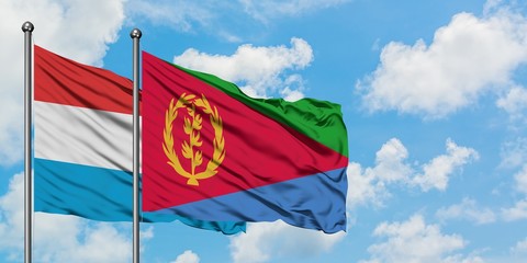 Luxembourg and Eritrea flag waving in the wind against white cloudy blue sky together. Diplomacy concept, international relations.