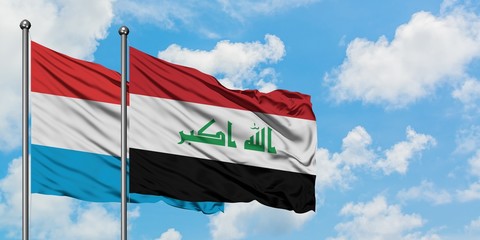 Luxembourg and Iraq flag waving in the wind against white cloudy blue sky together. Diplomacy concept, international relations.