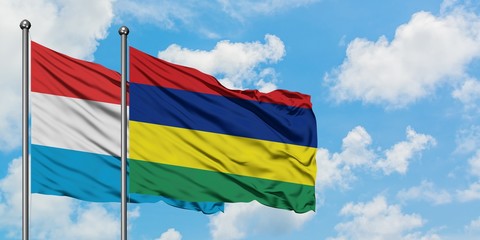 Luxembourg and Mauritius flag waving in the wind against white cloudy blue sky together. Diplomacy concept, international relations.