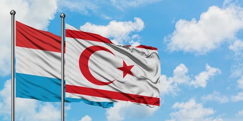 Luxembourg and Northern Cyprus flag waving in the wind against white cloudy blue sky together. Diplomacy concept, international relations.