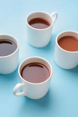 Cups of hot coffee on color background
