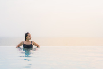 Portrait beautiful young asian woman happy smile relax around swimming pool in hotel resort