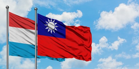 Luxembourg and Taiwan flag waving in the wind against white cloudy blue sky together. Diplomacy concept, international relations.