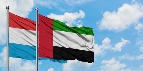 Luxembourg and United Arab Emirates flag waving in the wind against white cloudy blue sky together. Diplomacy concept, international relations.