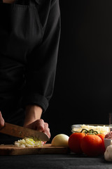 slicing onions, the chef prepares a tasty and healthy salad or other dish. Restaurant or hotel business, recipe book, menu. Vertical frame