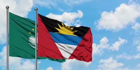 Macao and Antigua and Barbuda flag waving in the wind against white cloudy blue sky together. Diplomacy concept, international relations.