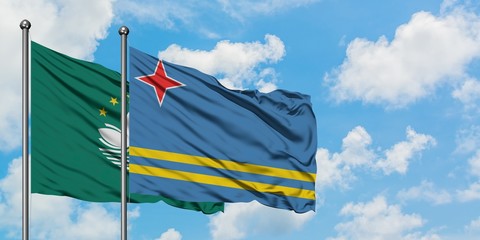Macao and Aruba flag waving in the wind against white cloudy blue sky together. Diplomacy concept, international relations.