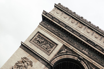 Obraz premium The iconic Arc the Triomphe in a blue sky day in Paris, France, Europe. Famous touristic places in Europe. European city travel concept.