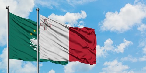 Macao and Malta flag waving in the wind against white cloudy blue sky together. Diplomacy concept, international relations.