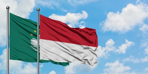 Macao and Monaco flag waving in the wind against white cloudy blue sky together. Diplomacy concept, international relations.