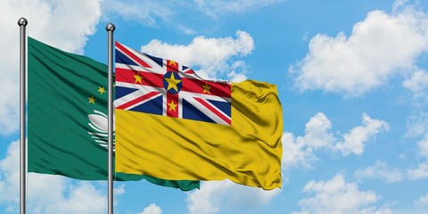 Macao and Niue flag waving in the wind against white cloudy blue sky together. Diplomacy concept, international relations.
