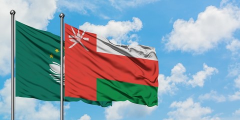 Macao and Oman flag waving in the wind against white cloudy blue sky together. Diplomacy concept, international relations.