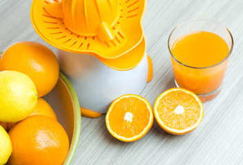 Glass of squeezed orange juice. Fresh and juicy oranges on the wooden table.