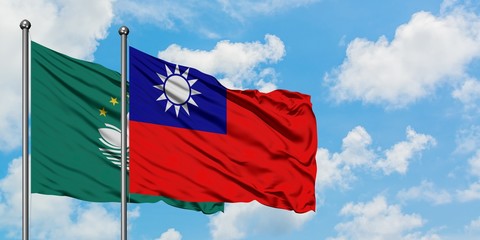 Macao and Taiwan flag waving in the wind against white cloudy blue sky together. Diplomacy concept, international relations.