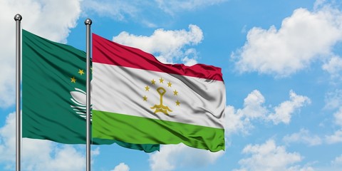 Macao and Tajikistan flag waving in the wind against white cloudy blue sky together. Diplomacy concept, international relations.