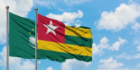 Macao and Togo flag waving in the wind against white cloudy blue sky together. Diplomacy concept, international relations.