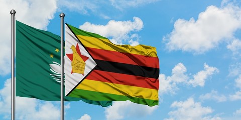 Macao and Zimbabwe flag waving in the wind against white cloudy blue sky together. Diplomacy concept, international relations.