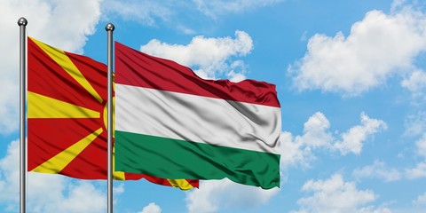 Macedonia and Hungary flag waving in the wind against white cloudy blue sky together. Diplomacy concept, international relations.