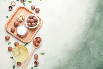 Macadamia nuts with oil and cosmetic cream on color background