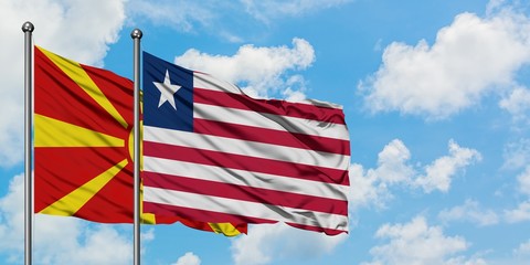 Macedonia and Liberia flag waving in the wind against white cloudy blue sky together. Diplomacy concept, international relations.