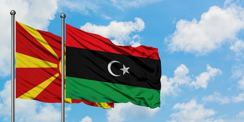 Macedonia and Libya flag waving in the wind against white cloudy blue sky together. Diplomacy concept, international relations.