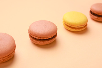 Different tasty macarons on color background