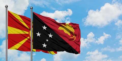 Macedonia and Papua New Guinea flag waving in the wind against white cloudy blue sky together. Diplomacy concept, international relations.