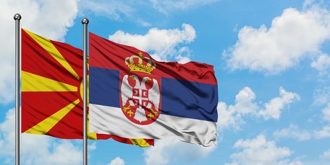 Macedonia and Serbia flag waving in the wind against white cloudy blue sky together. Diplomacy concept, international relations.
