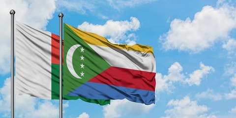 Madagascar and Comoros flag waving in the wind against white cloudy blue sky together. Diplomacy concept, international relations.