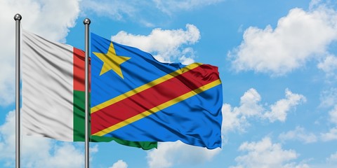 Madagascar and Congo flag waving in the wind against white cloudy blue sky together. Diplomacy concept, international relations.