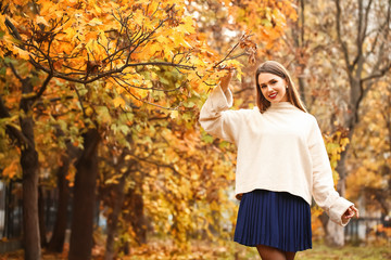 Stylish young woman in autumn park