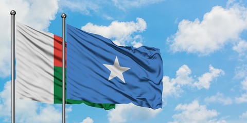 Madagascar and Somalia flag waving in the wind against white cloudy blue sky together. Diplomacy concept, international relations.