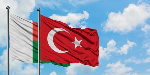 Madagascar and Turkey flag waving in the wind against white cloudy blue sky together. Diplomacy concept, international relations.