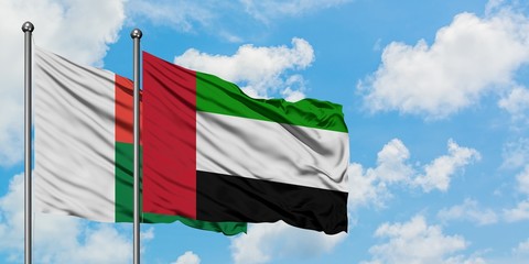 Madagascar and United Arab Emirates flag waving in the wind against white cloudy blue sky together. Diplomacy concept, international relations.