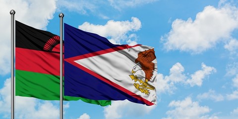 Malawi and American Samoa flag waving in the wind against white cloudy blue sky together. Diplomacy...