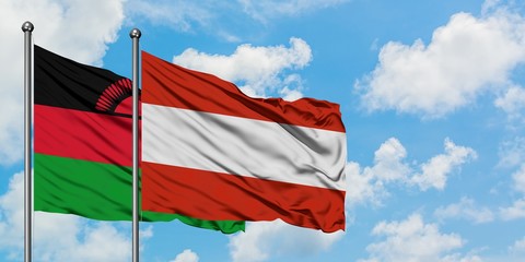 Malawi and Austria flag waving in the wind against white cloudy blue sky together. Diplomacy concept, international relations.