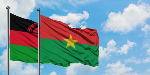 Malawi and Burkina Faso flag waving in the wind against white cloudy blue sky together. Diplomacy concept, international relations.