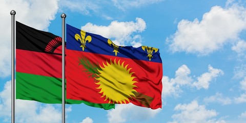 Malawi and Guadeloupe flag waving in the wind against white cloudy blue sky together. Diplomacy concept, international relations.