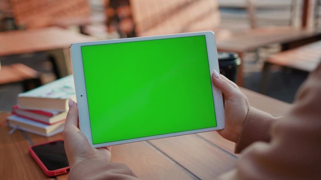 Woman hands sitting on cafe use tablet computer with horizontal green screen typing display internet touchpad connection touchscreen communication chroma finger message mobile slow motion