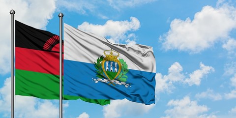 Malawi and San Marino flag waving in the wind against white cloudy blue sky together. Diplomacy concept, international relations.